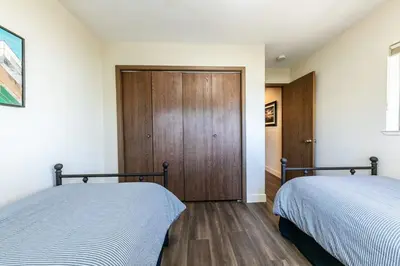 a bedroom with two beds and a wooden door at Tahoe Vista Retreat with Lake View Walk to beach in Tahoe Vista