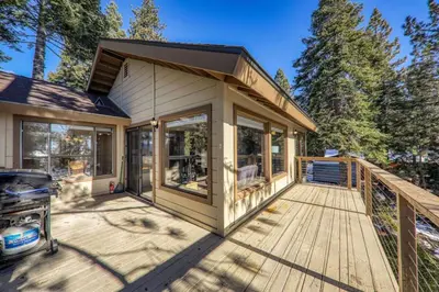 a small house with a large deck with windows at Tahoe Vista Retreat with Lake View Walk to beach in Tahoe Vista