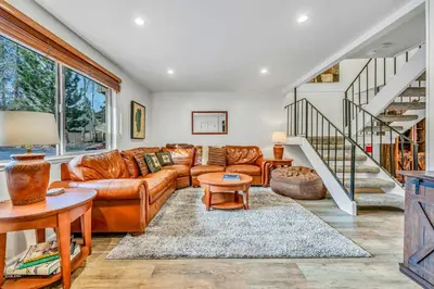 a living room with a leather couch and a staircase at Modern 3BD -Walk to Lake & Beach in Tahoe City