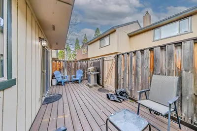 a wooden deck with two chairs and a grill at Modern 3BD -Walk to Lake & Beach in Tahoe City