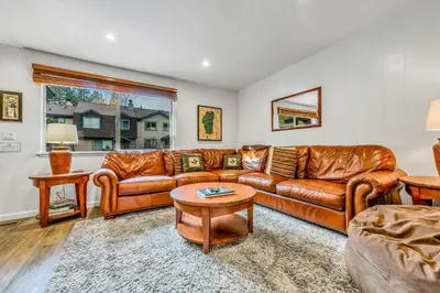 a living room with a leather couch and a table at Modern 3BD -Walk to Lake & Beach in Tahoe City