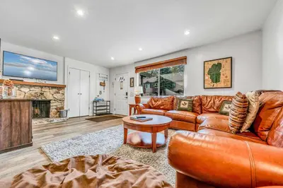 a living room with a leather couch and a fireplace at Modern 3BD -Walk to Lake & Beach in Tahoe City
