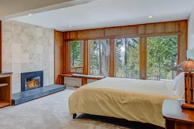 a bedroom with a large bed and a fireplace at Lakeview Hideaway in Kings Beach