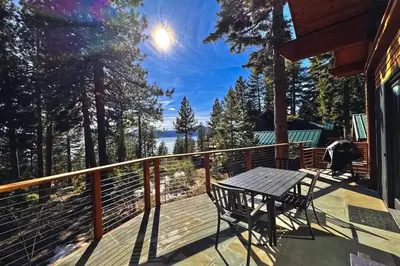 a table and chairs on a deck with a view of the water at Lakeview Hideaway in Kings Beach