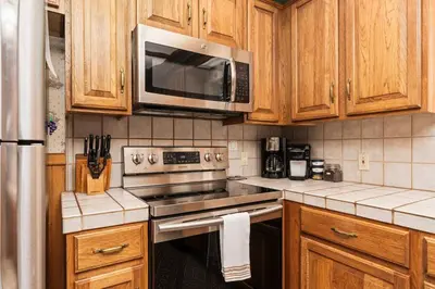 a kitchen with a stove and a microwave at Toste Cabin- Spacious 3BR Cabin in East Village! in Shaver Lake