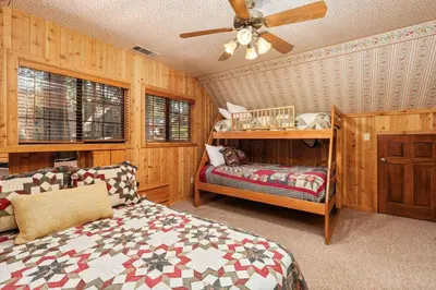 a bedroom with a bed and a ceiling fan at Toste Cabin- Spacious 3BR Cabin in East Village! in Shaver Lake