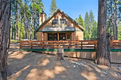 a cabin in the woods with two trees at Toste Cabin- Spacious 3BR Cabin in East Village! in Shaver Lake