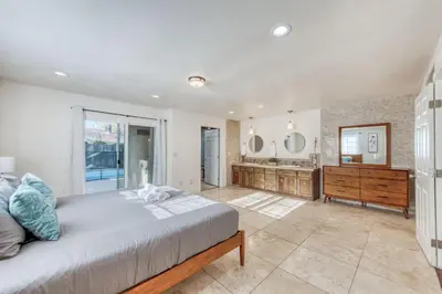 a bedroom with a large bed and a bathroom at Fig Garden 4BR House W Pool in Fresno