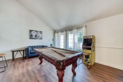 a living room with a pool table and a tv at Fig Garden 4BR House W Pool in Fresno