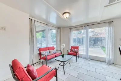 a living room with red chairs and a table and windows at Fig Garden 4BR House W Pool in Fresno
