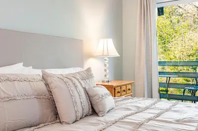 a bedroom with a bed with a window and a lamp at Sierra Vista Lookout Lodge with Creek, Waterfall and Waterholes, minutes from Bass Lake and Yosemite South Gate in North Fork