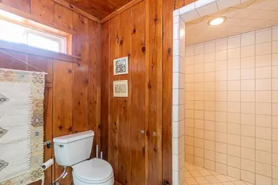 a bathroom with wooden walls and a toilet and a shower at Sierra Vista Lookout Lodge with Creek, Waterfall and Waterholes, minutes from Bass Lake and Yosemite South Gate in North Fork