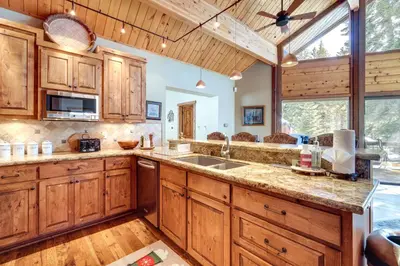 a large kitchen with wooden cabinets and a large window at One Moose Lodge with Hot Tub in Tahoe Donner in Truckee