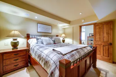a bedroom with a bed and a lamp on a dresser at One Moose Lodge with Hot Tub in Tahoe Donner in Truckee