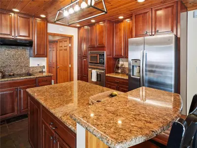 a kitchen with wooden cabinets and a stainless steel refrigerator at High Sierra Escape - Cozy, Spacious Mountain Home in South Lake Tahoe