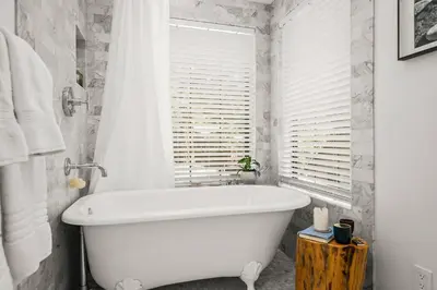 a white bath tub in a bathroom with a window at Private Ski, Lake & Golf Chalet! Walk to Lake in Tahoe Vista