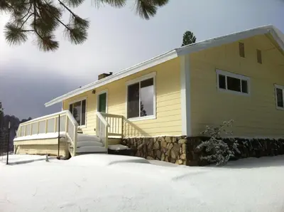 a yellow tiny house in the snow at Black Oak Hill Vista near Yosemite - mountain views & starry night sky in Mariposa