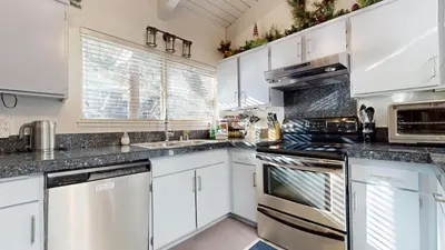 a kitchen with white cabinets and stainless steel appliances at Mammoth Estates #225 condo in Mammoth Lakes