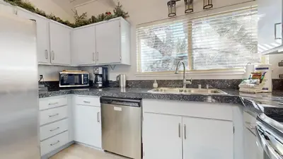 a kitchen with white cabinets and a sink at Mammoth Estates #225 condo in Mammoth Lakes
