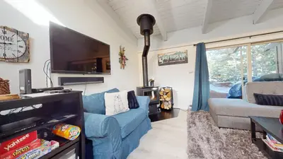 a living room with a blue couch and a tv at Mammoth Estates #225 condo in Mammoth Lakes