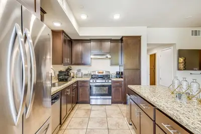 a kitchen with wooden cabinets and stainless steel appliances at Charming Patterson Condo with Grilling Stations in Patterson