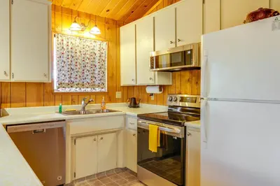 a kitchen with white cabinets and a white refrigerator at Serene Groveland Cabin Rental Near Yosemite! in Groveland