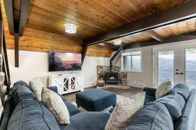 a living room with a blue couch and a fireplace at Rustic and Modern 3BDR Tahoe Cabin in Tahoe City