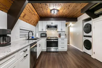 a kitchen with white cabinets and a wooden ceiling at Rustic and Modern 3BDR Tahoe Cabin in Tahoe City