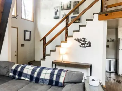 a living room with a couch and a staircase at Summer Escape Chalet with Pool Access in BLS in Arnold