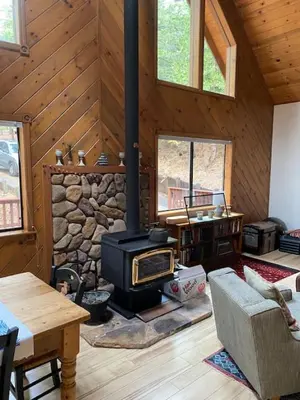 a living room with a woodburning stove in a cabin at Gorgeous cabin in BLS with EV Chgr, Pool Access and Gameroom in Arnold