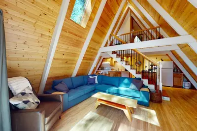 a living room with a blue couch and a staircase at Peaceful Pine Getaway in Dorrington