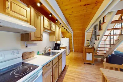 a kitchen with wooden cabinets and a staircase in a house at Peaceful Pine Getaway in Dorrington
