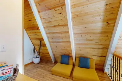 two yellow chairs in a room with wooden walls at Peaceful Pine Getaway in Dorrington
