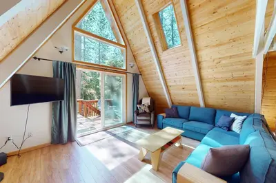 a living room with a blue couch and a tv at Peaceful Pine Getaway in Dorrington