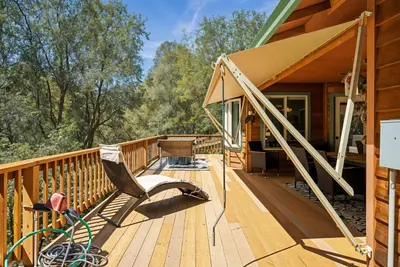 a wooden deck with a chair on a house at The Nut House - Lovely Home with Hot Tub home in Groveland