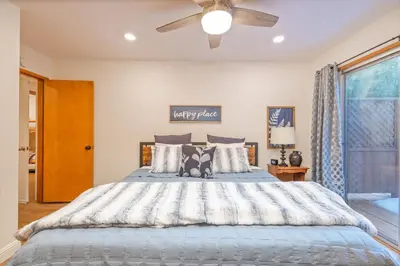 a bedroom with a large bed with a ceiling fan at Corlieu Falls Cabin in Sugar Pine 8 miles from Yosemite with Gazebo, Hot tub a shack and Bar top in Oakhurst