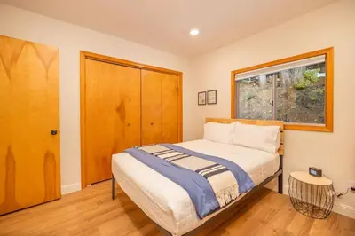 a bedroom with a bed and a window at Corlieu Falls Cabin in Sugar Pine 8 miles from Yosemite with Gazebo, Hot tub a shack and Bar top in Oakhurst