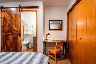 a bedroom with a bed and a desk with a chair at Corlieu Falls Cabin in Sugar Pine 8 miles from Yosemite with Gazebo, Hot tub a shack and Bar top in Oakhurst