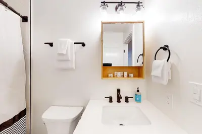 a white bathroom with a sink and a mirror at Piney Point in Arnold