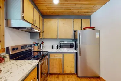 a kitchen with a stainless steel refrigerator and wooden cabinets at Beaver Lodge in South Lake Tahoe