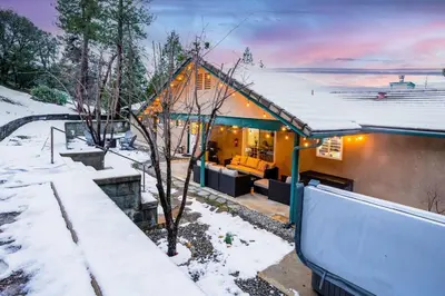 a house in the snow with a snow covered yard at Country Club Hideout - w/ HotTub, King bed in Oakhurst